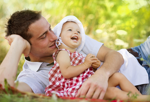 Happy young father spending time outdoor on a summer day with his beautiful daughter